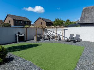 a backyard with a yard with green grass at Newly Renovated Luxury Bungalow Pass the Keys in Ulverston
