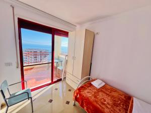 a bedroom with a bed and a large window at Casa del Mar 2 in Durrës