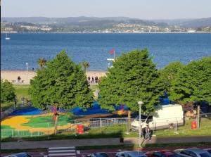 a park with trees and the ocean in the background at Miramar Suites in Sada