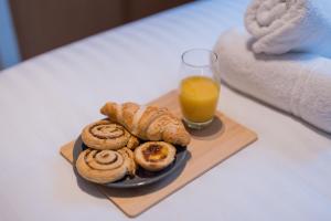 a plate of cinnamon rolls and a glass of orange juice at BALCONY & PARKING Sleeps 6 City Centre NEW in Wolverhampton +19 photos