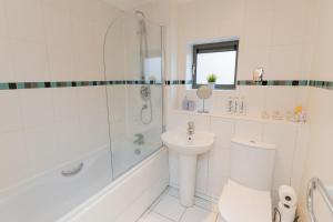 a white bathroom with a sink and a tub and a toilet at BALCONY & PARKING Sleeps 6 City Centre NEW in Wolverhampton