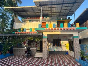 a house with a motorcycle parked in front of it at Cozy Glick in Varkala