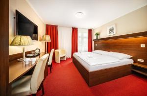 ein Hotelzimmer mit einem Bett und einem Schreibtisch in der Unterkunft Martin Hotel Prague in Prag