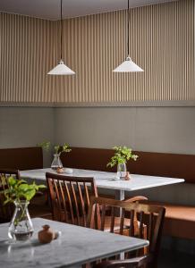 a restaurant with tables and chairs and pendant lights at Stay North Matri House Anni in Mathildedal