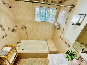 a bathroom with a bath tub and a window at Spacious 3 Bedroom Home Near LA Close to Disneyland, Universal, Free Parking and Yard in Montebello +42 photos