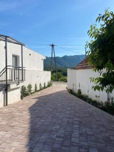 a brick walkway next to a white building at Emily in Slime