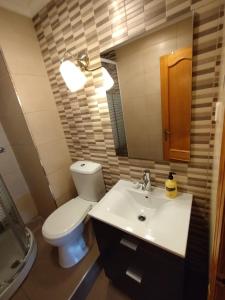 a bathroom with a toilet and a sink and a mirror at valenia city in Valencia +3 photos