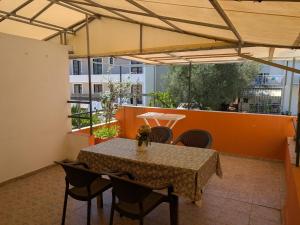 a table and chairs in a room with an orange wall at Apartmani Abeona in Budva