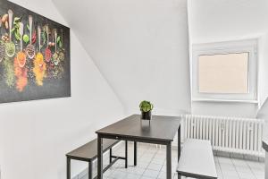 a dining room with a table and a painting on the wall at PF03 Innenstadt Apartment für Monteure und Teams - NEU Monteurunterkünfte in Pforzheim - LS CrewComfort auch für weitere Unterkünfte in Pforzheim +6 photos