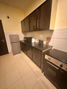 a kitchen with black cabinets and a refrigerator at Pasha Nova in Murree +21 photos