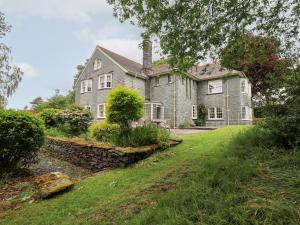an old house with a stone wall in the yard at Little Ellers in Portinscale