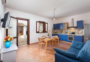 a kitchen and dining room with a table and blue cabinets at SanVitoTour - Covo deI Pirati in San Vito lo Capo