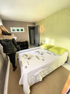 Villa 12 personnes au calme avec piscine في Puget-Ville: امرأة تقف بجانب سرير في غرفة النوم