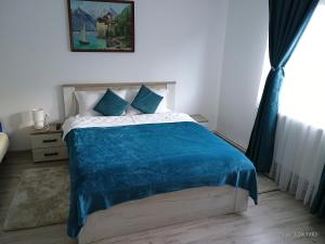 una camera da letto con un letto con una coperta blu di Casa FLOREA a Vama Buzăului