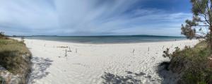 a sandy beach with the ocean in the background at Bungalow am Strand in Altenkirchen