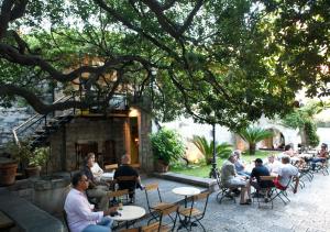 un grupo de personas sentadas en mesas en un patio en B&B Sesame Inn, en Dubrovnik