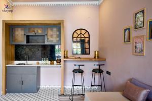 a kitchen with a sink and a counter with stools at Hotel Amaiti by stayxp in Pondicherry