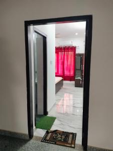 a mirror in a bathroom with a red curtain at Stay For Couples Near IIM College in Lucknow