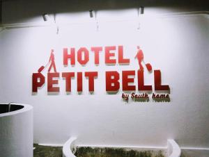 Un cartel de campana en la pared de un baño. en Hotel PUTIT BELLプチベル-1台駐車無料イオンモール沖縄ライカムまで車で6分, en Okinawa City
