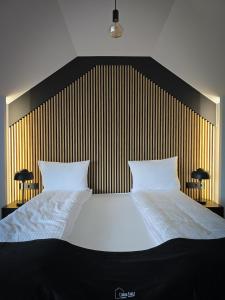 una camera da letto con un grande letto bianco con due cuscini di Czarna Chata Beach & SPA a Klimkówka