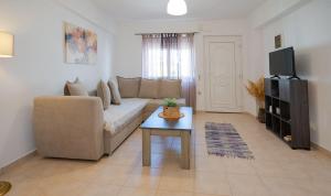 a living room with a couch and a table at Gialos Coral - 30 meters from sandy beach in Makry Gialos