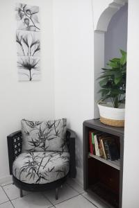 a chair in a room with a book shelf at Villa Solara Your Spacious, Central, Affordable Stay in Kingston in Kingston