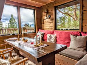 a wooden table in a room with windows at Tretopphytta Kraggbua in Snerta