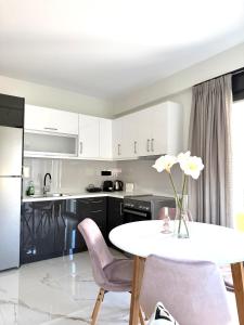 a kitchen with a white table and purple chairs at DK Luxury Living in Ioannina