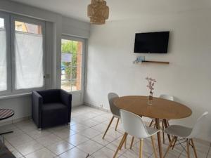 a living room with a table and a chair at Rêve d'été Bray-dunes in Bray-Dunes