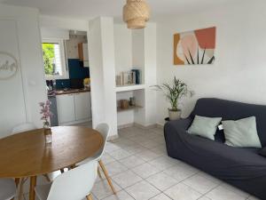 a living room with a blue couch and a table at Rêve d'été Bray-dunes in Bray-Dunes