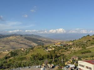 a town on a hill with mountains in the background at Mariù in Agira +23 photos