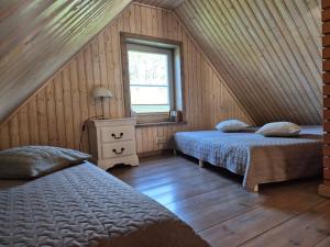 a bedroom with two beds and a window at Kõverajärve saunamaja in Nedsaja