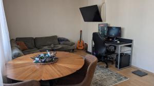 a living room with a wooden table and a couch at Cozy apartment in Prishtinë