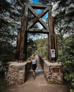 a woman walking across a bridge in a forest at Premium Slope-Side Escape I Alpen Villas at Powderhorn Mountain in Bessemer