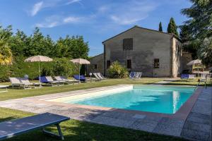 a swimming pool in front of a building with chairs and anophethritisthritisthritis at B&B Panizzi - San Gimignano in San Gimignano