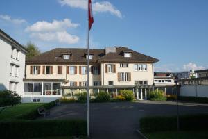 a large building with a flag in front of it at Hostel Eckstein in Zug
