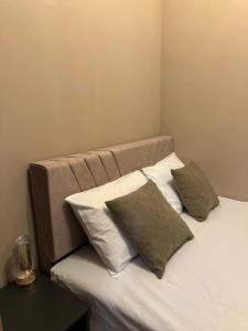 a bed with three pillows on it in a room at CA Yerevan Hotel in Yerevan