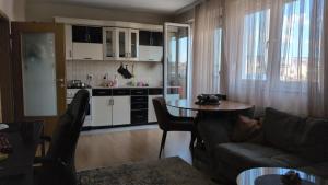 a living room with a couch and a table at Cozy apartment in Prishtinë