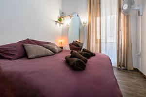 a large purple bed with three pillows on it at Kharmen A 1565s House with Seaviews in Birgu