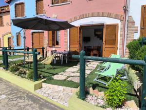 een huis met een patio met een parasol en stoelen bij L'Infinito Tanca Piras in Nebida +57 foto's