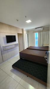 a bedroom with a bed and a flat screen tv at Piazza diRoma - Apartamentos JN in Caldas Novas +107 photos