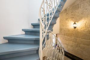 a stairway with blue steps and a light fixture at Kharmen A 1565s House with Seaviews in Birgu