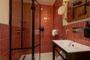 a bathroom with a shower and a sink at NH Copenhagen Grand Joanne in Copenhagen