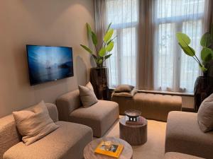 a living room with a couch and chairs and a tv at Holiday Home in Antwerp in Antwerp