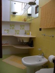 a bathroom with a sink and a toilet and a mirror at Villa Lea in Custonaci