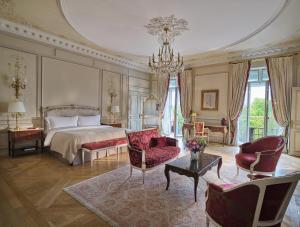 a large bedroom with a bed and a chandelier at Le Meurice – Dorchester Collection in Paris