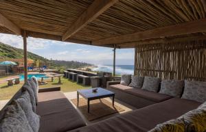 a living room with couches and a view of the ocean at Widdy's Beach Club in Umkomaas