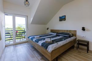 LičVilla SIN的一间卧室，里面有一张床和一扇大窗户。