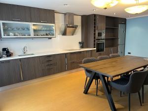 a kitchen with a wooden table and some chairs at Apartamento centrico en edificio histórico in Albacete