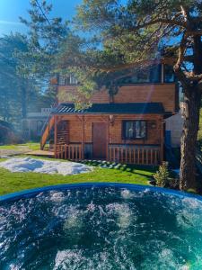 a log cabin with a pool in front of a house at Villa INDIANA Devin in Devin